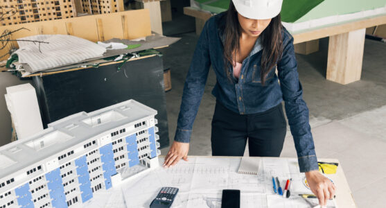 african-american-lady-safety-helmet-standing-near-model-building