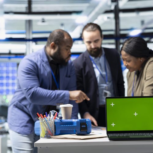 Coworkers brainstorming solutions with mockup display in solar plant, advancing industrial goals through collaboration and corporate responsibility. Team of engineers share insight.