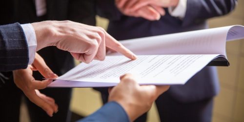 Cropped view of businesswomen reading document. Closeup shot of female finger pointing at page. Business concept