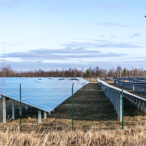 View of the solar power plant on a green field. Electric farm with panels for producing clean ecologic energy.