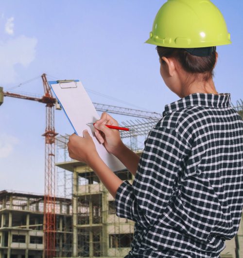 women asian engineer inspecting and working and holding blueprints at construction site