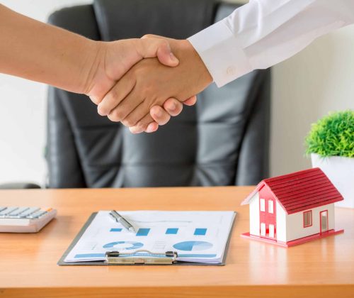 Side view hands of agent and client shaking hands after signed contract buy new apartment.