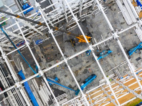 Aerial top view construction site with industrial machinery building for new  factory buildings.
