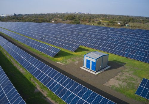 Huge solar power plant to use solar energy in a picturesque green field in Ukraine. Aerial panoramic drone shot