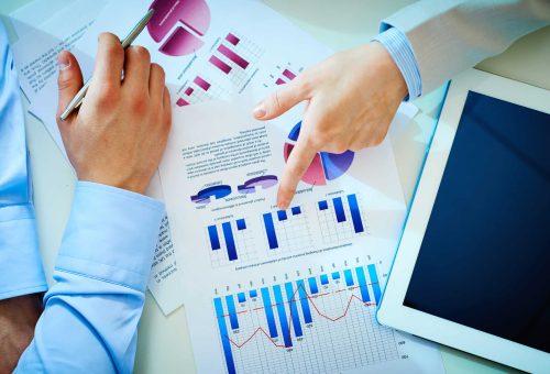 Close-up of female hand pointing at business document while explaining chart