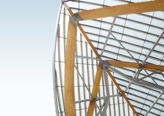 A vertical low angle shot of a metal and wooden building under the blue sky